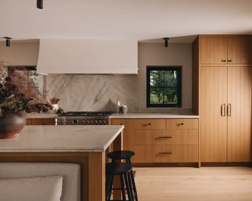 design interieur cuisine moderne lac brome Cuisine moderne avec îlot en marbre, armoires en bois clair et cuisinière professionnelle. Design d'intérieur élégant à Lac-Brome, Cantons-de-l'Est.