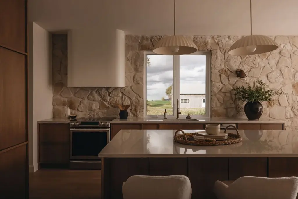 cuisine rustique moderne pierre projet st louis Aménagement d'une cuisine rustique moderne avec mur de pierre naturelle et îlot central réalisée